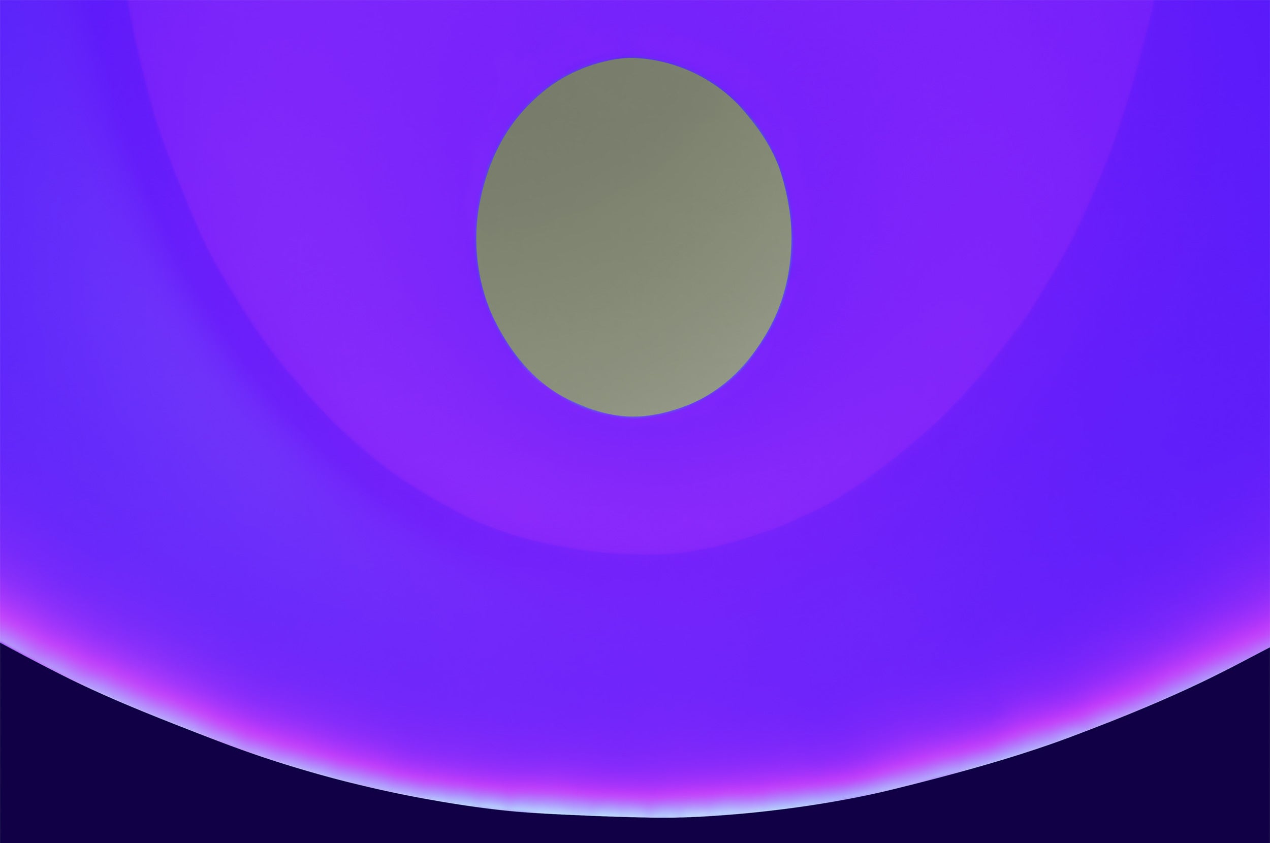 Photo of the ceiling colored with magenta and blue lights and a gray-green oculus.